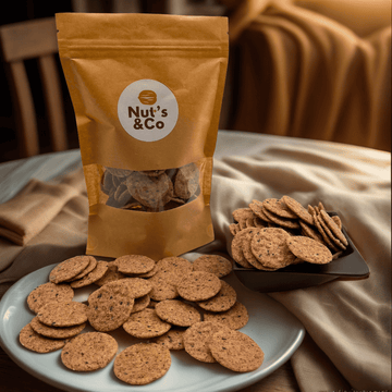 Bol de crackers au poivre à côté d’un paquet avec une étiquette NutsAndCo contenant des crackers au poivre, avec des crackers étalés par terre.