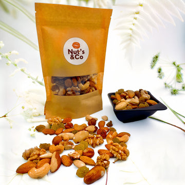Bol de mix Vitalité & Énergie à côté d’un paquet avec une étiquette NutsAndCo contenant le mix Vitalité & Énergie, avec des ingrédients étalés par terre.